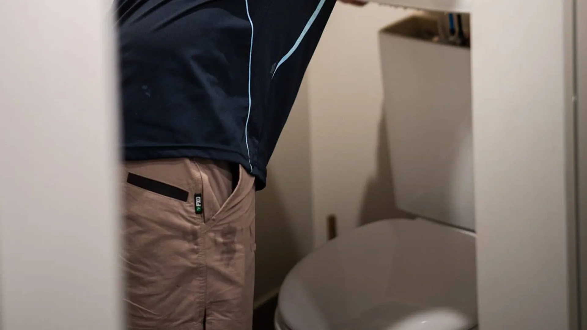 Plumber checking a toilet cistern
