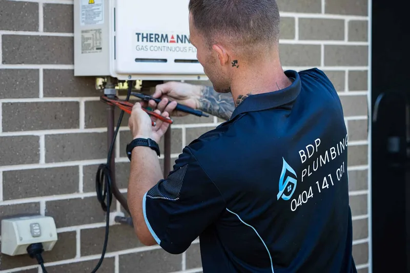Plumber servicing a continuous-flow gas hot water unit