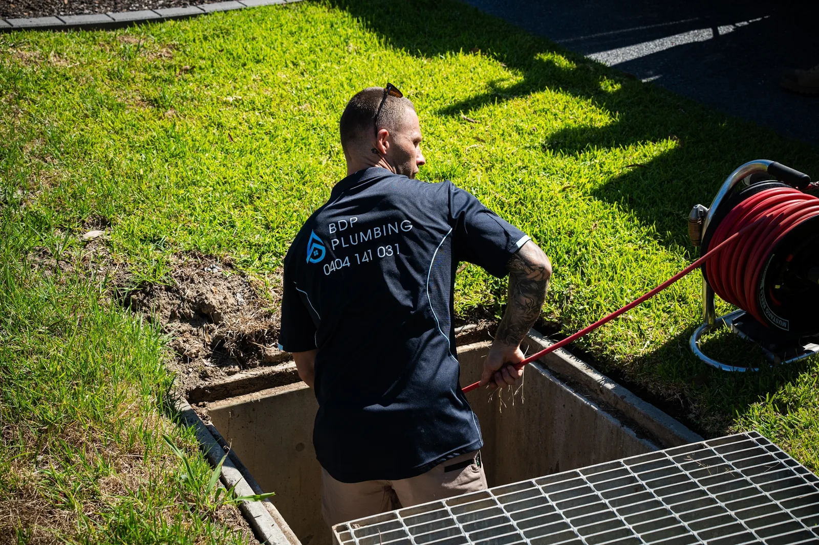 Plumber clearing a stormwater pit with a jetter hose