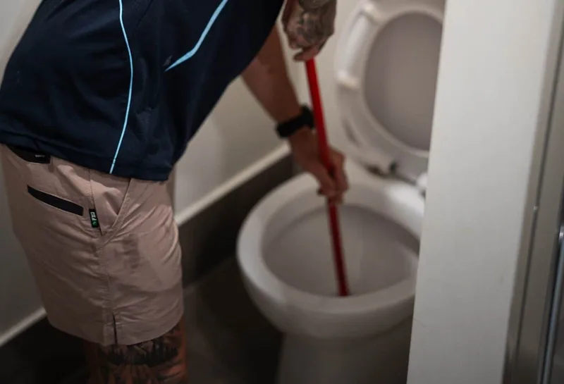 Plumber clearing an overflowing toilet